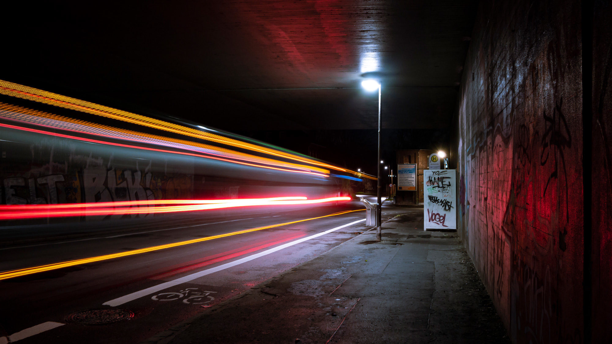 Eine Kurzgeschichte mit dem Namen: Messerstecherei. Das Bild zeigt eine dunkle Brücke bei Nacht. Die Lichter eines Busses sind aufgrund hoher Belichtungszeit nur als Linien zu erkennen